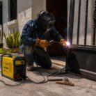 Soldador soldando una puerta con la soldadora KMA200PRO para electrodo
