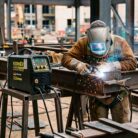 Hombre soldando en construcción industrial con la soldadora KMI205PRO