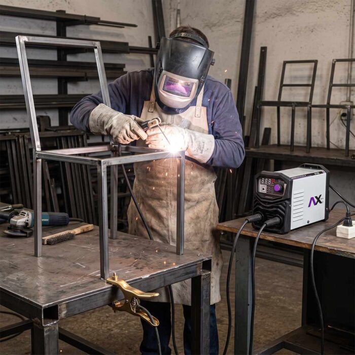 Hombre soldando una silla metálica con la Soldadora inversor electrodo TIG Lift 140A en un taller