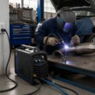 Soldador trabajando en una pieza metálica automotriz con la Soldadora Redbo TIG-200 | Inversora TIG/MMA