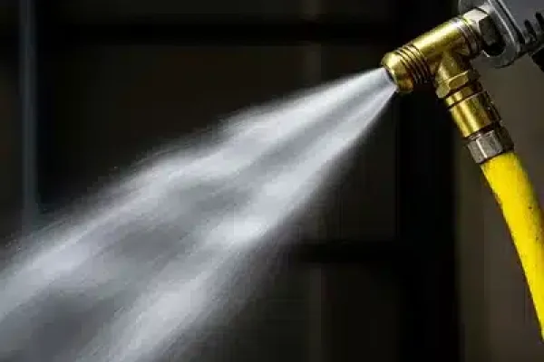 Salida de aire a presión desde la manguera, representando el mantenimiento de compresores de aire en acción.