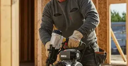 Profesional de la construcción utilizando un compresor para clavar, ideal para destacar el mantenimiento de compresores de aire.